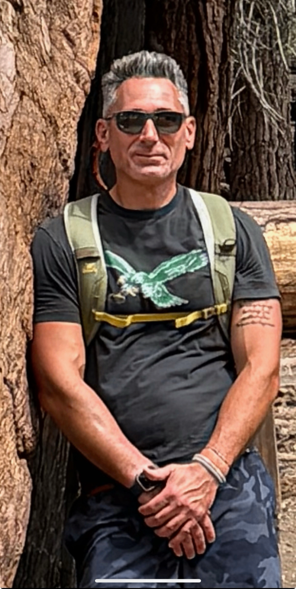 Portrait leaning against a tree in the forest