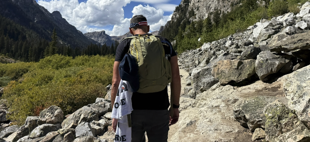 Hiker on a mountain trail looking out across a granite valley